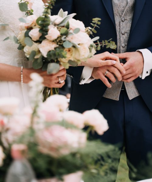 a bride with bouquet and the groom in the garden